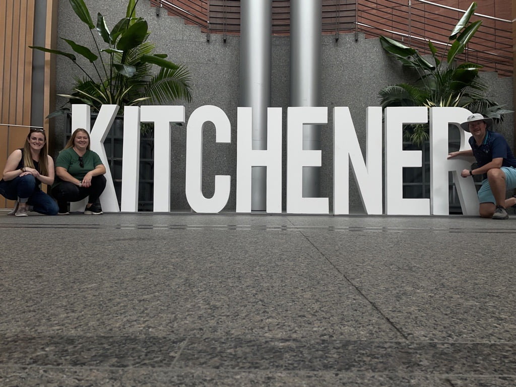 Chelsea, Joanna, and Jared pose next to the giant KITCHENER sign at Kitchener City Hall