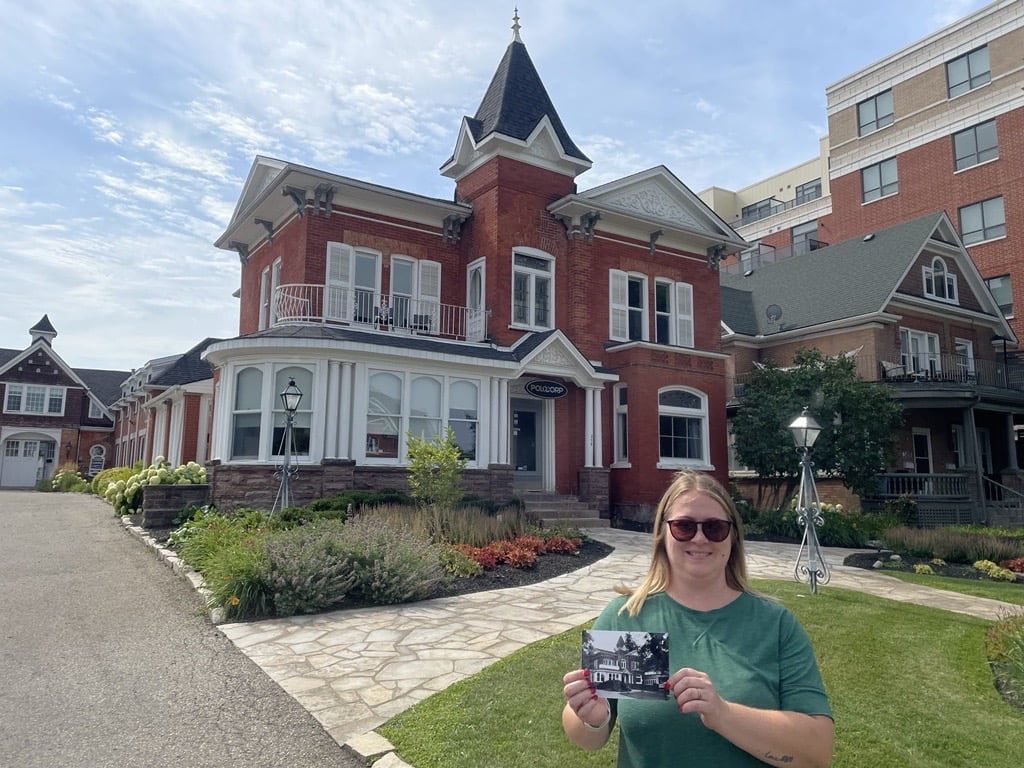 Joanna stands in front of the Buena Vista holding an old photograph of the same house